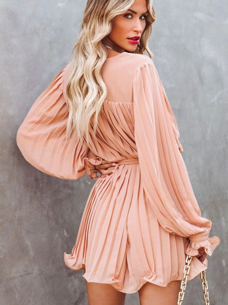 Playful V-neck Pink Pleated Romper Dress features a tie waist With a buttoned front.