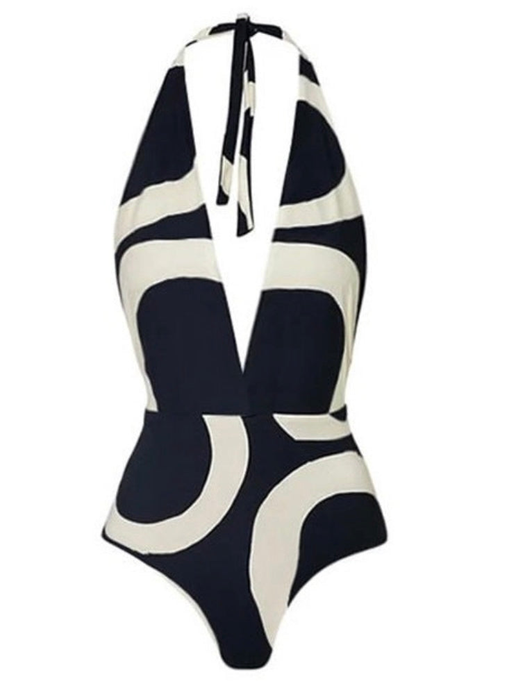 One -piece swimwear features a playful bow tie and a halter style unique irregular circle print in black and creamy white.