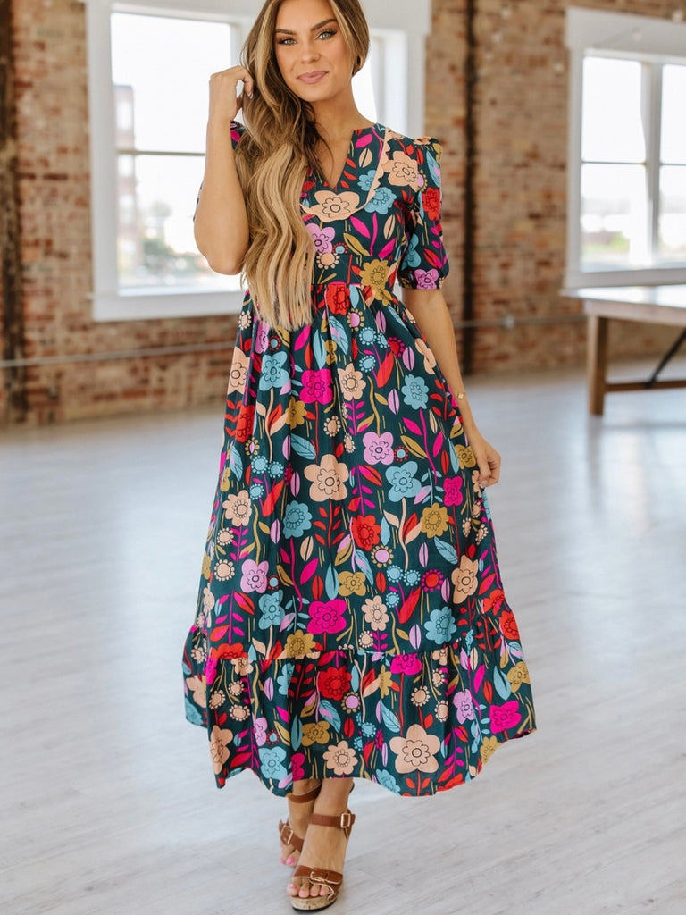 Maxi -dress features elegant puff sleeves, a flowy silhouette, and a bright floral print.