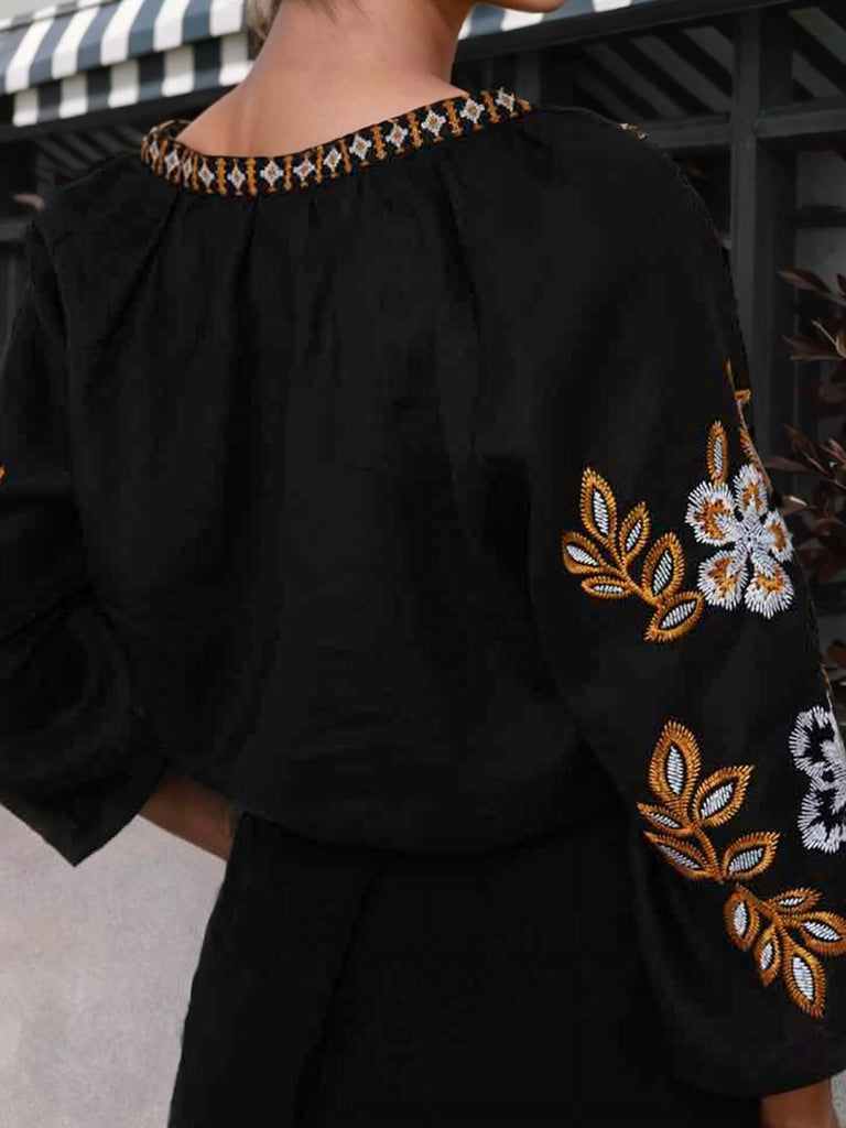 Black v-neck top with stunning embroidered detail on the sleeve