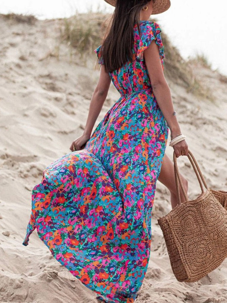 Floral Dress in vibrant shades of blue, and orange, with a high waist and side slit the v-neck wrap offers an adjustable fit.