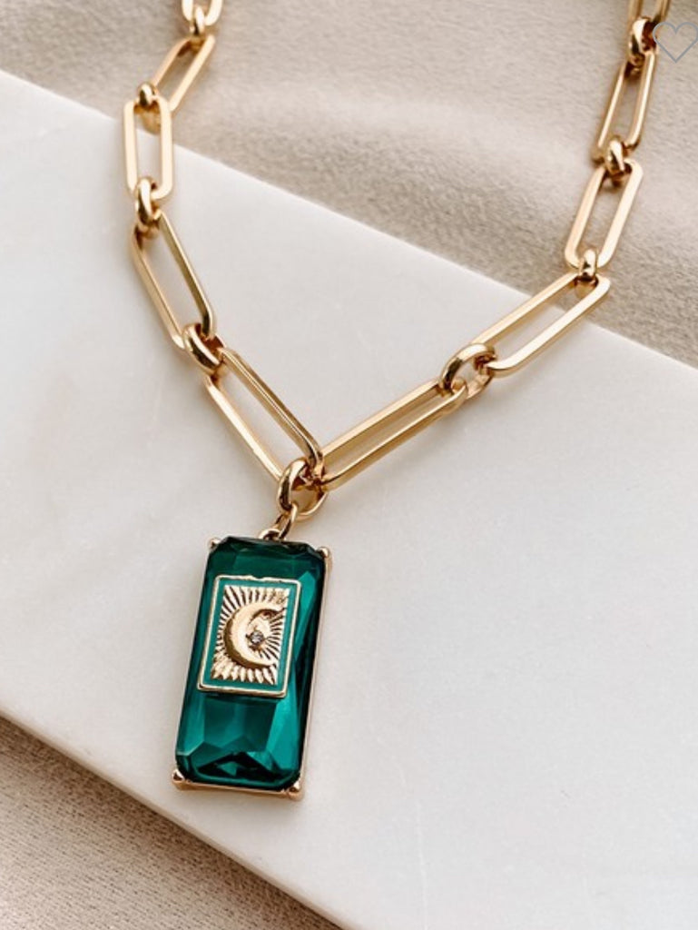 14.5" Gold Necklace, has a moon and star charm, and emerald gem detail with adjustable length and rectangular cable chain.