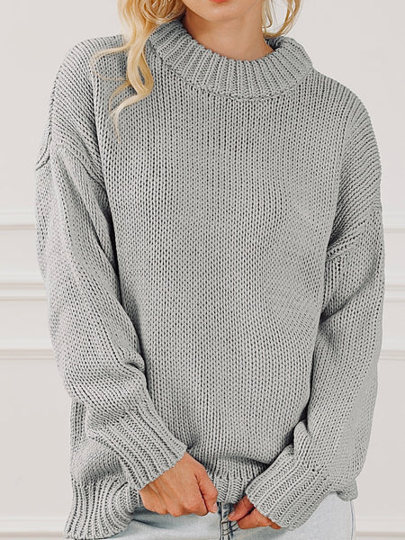 Chunky grey knit sweater with long sleeves.