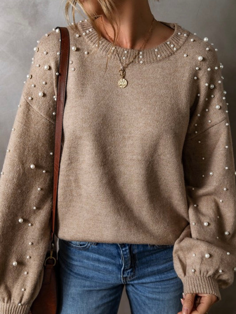 Neutral beige colour sweater with white pearls throughout, with a drop shoulder design and classic round neck .