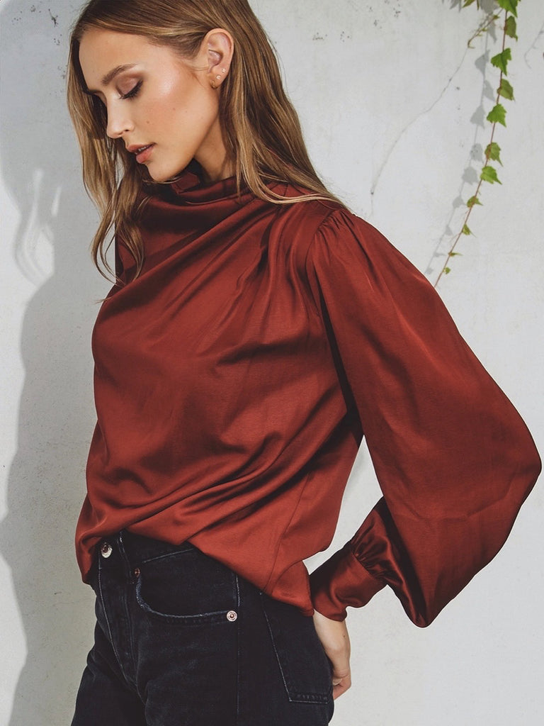 Claret coloured cinch blouse , Features a mock neck, and keyhole closure . Pleating detail on the shoulders and triple buttoned cuffs