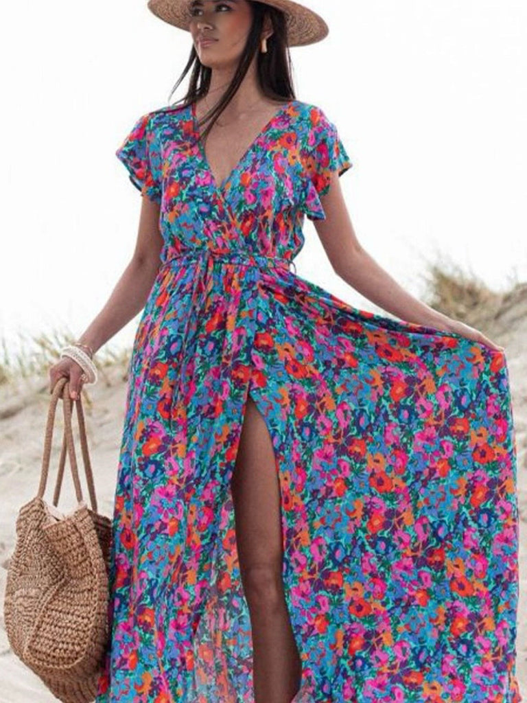  Floral Dress in vibrant shades of blue, and orange, with a high waist and side slit the v-neck wrap offers an adjustable fit.