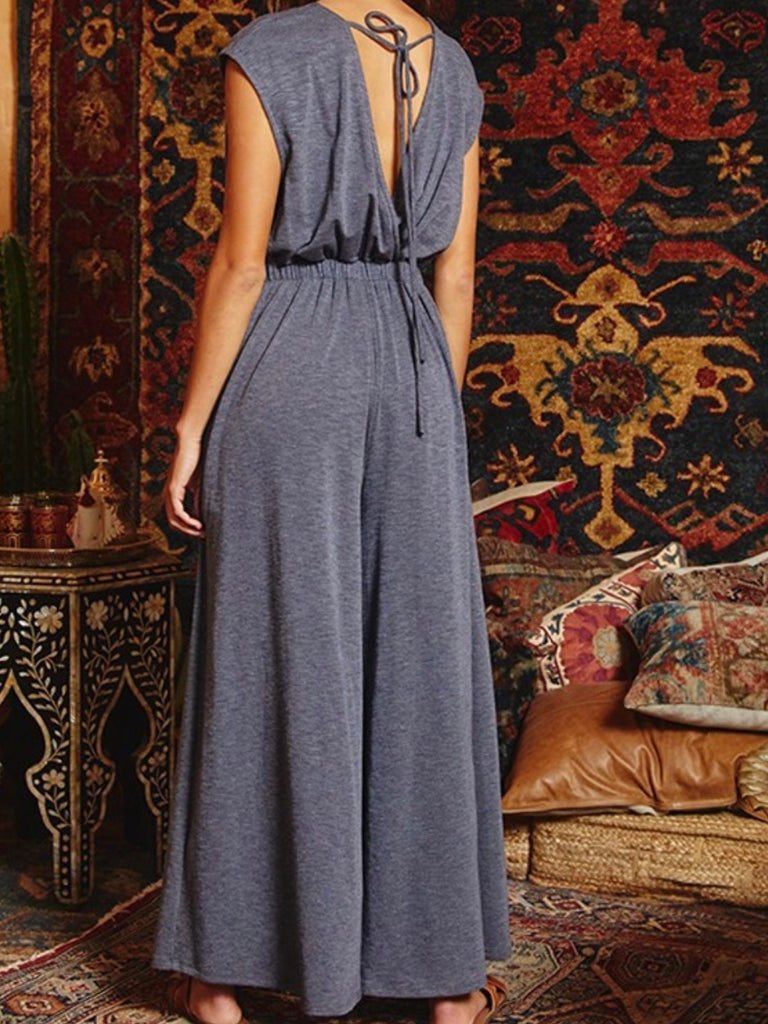 Navy Jumpsuit, with an open front that can be tied and a v-neckline at the back with a drawstring and elastic waistband, with wide legs and side pockets.