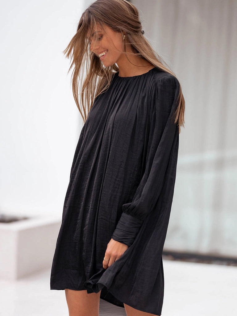 Black pleated mini dress with bishop sleeves.