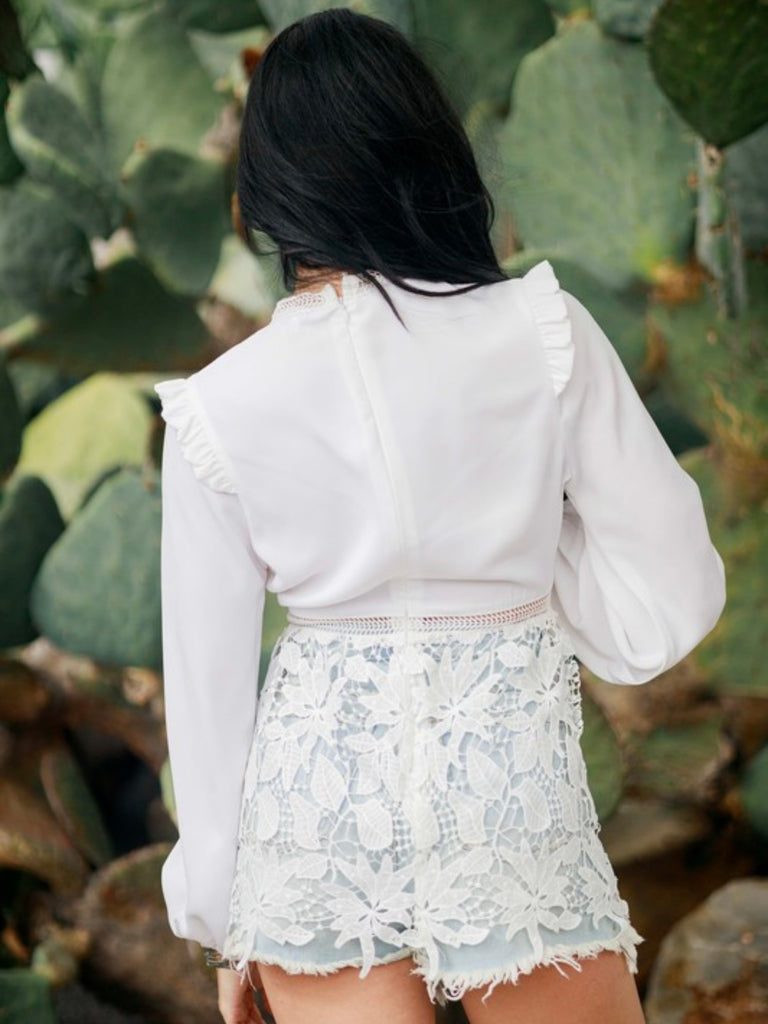 Lace Blouse in White, with ruffled shoulders and neckline and has intricate lace details .