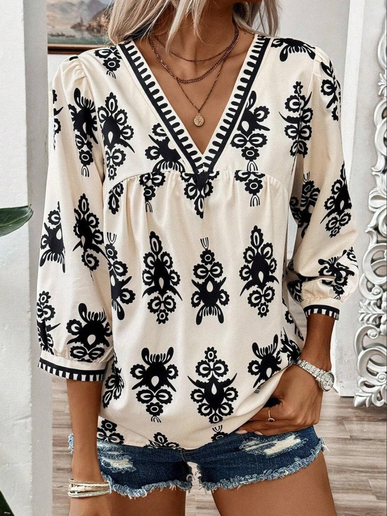  Features V-neck with delicate puff sleeves in a creamy color with a black print ikat design .