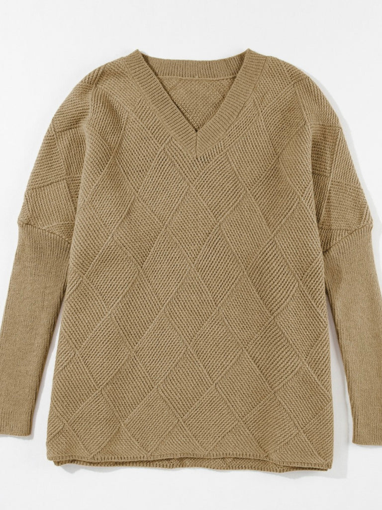 Camel oversized sweater with v-neck and batwing sleeve. A monochromatic checkered pattern. Acrylic blend