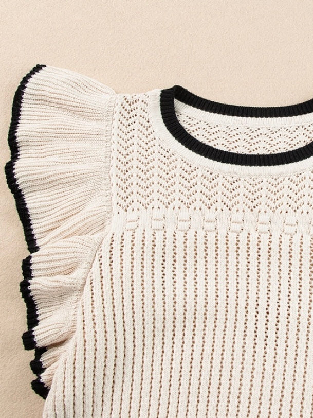 Crochet Knit fabric Cropped top in a Creamy white with black trim and has a contrast flounced trim sleeve detail.