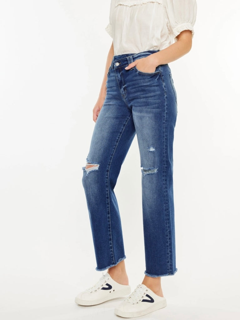 High Rise Button Closure 90's Cross Over Waist Jeans in a Dark Wash ,with whiskering details, minor distress on the knees and a scissor cut hem.