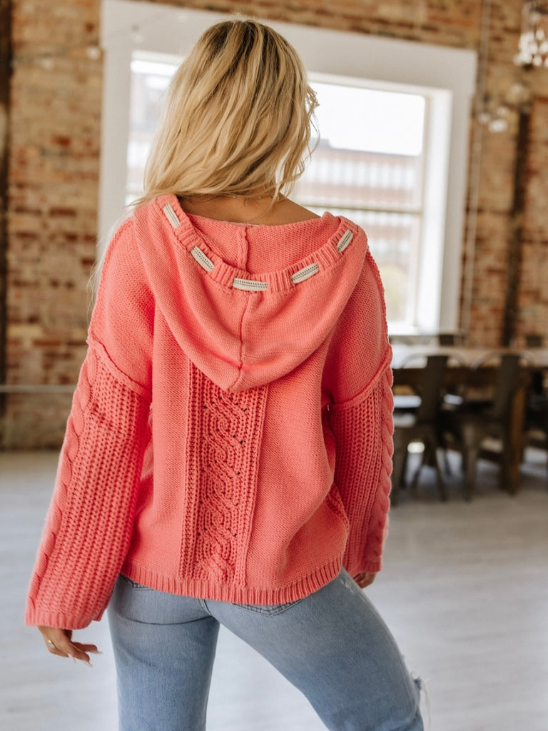 Coral  Cropped cable knit hooded sweater, the drawstring allows for an adjustable fit.