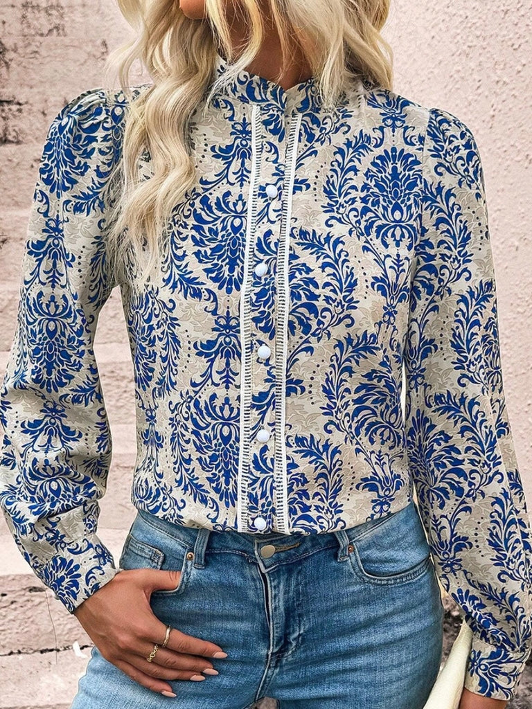 Button up top features dramatic bishop sleeves and delicate lace details, soft neutral background with a blue accent motif throughout.