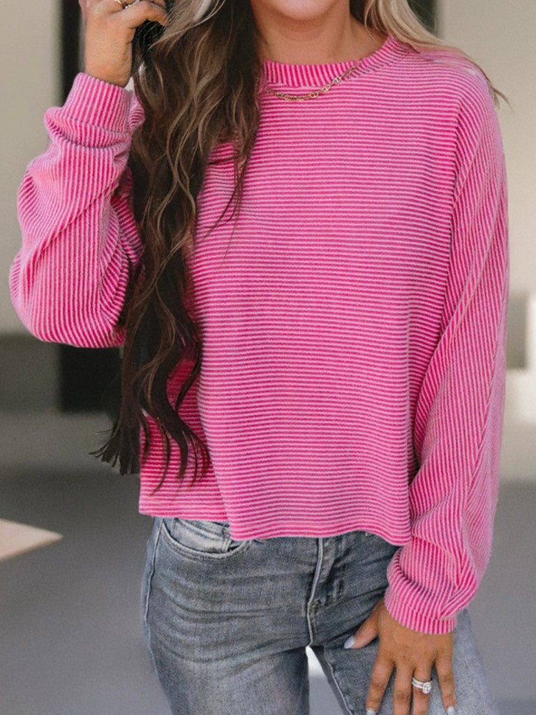 Pink corded top with long sleeves.