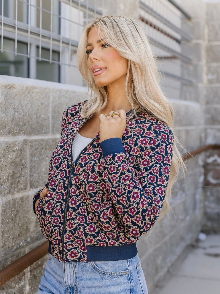 Magenta Flower Bomber Jacket with purple flowers on navy background and zip front.