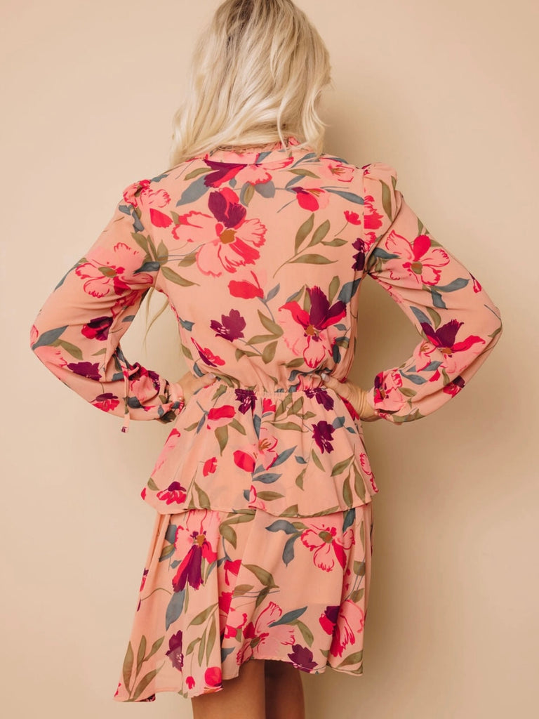 Midi Dress with tiered skirt , and v -neckline and mock button details features a frilled floral ruffle design, with a peachy pink and burgundy floral print.