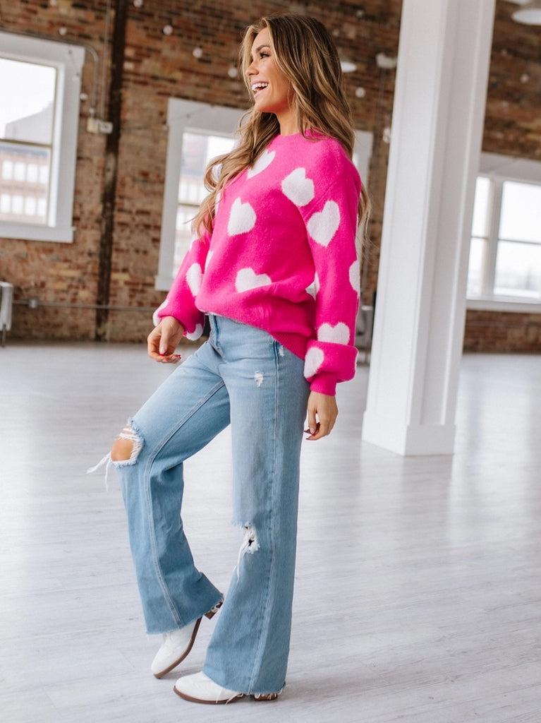 Soft, fuzzy sweater with white hearts on bright pink fabric. Made from 100% acrylic.