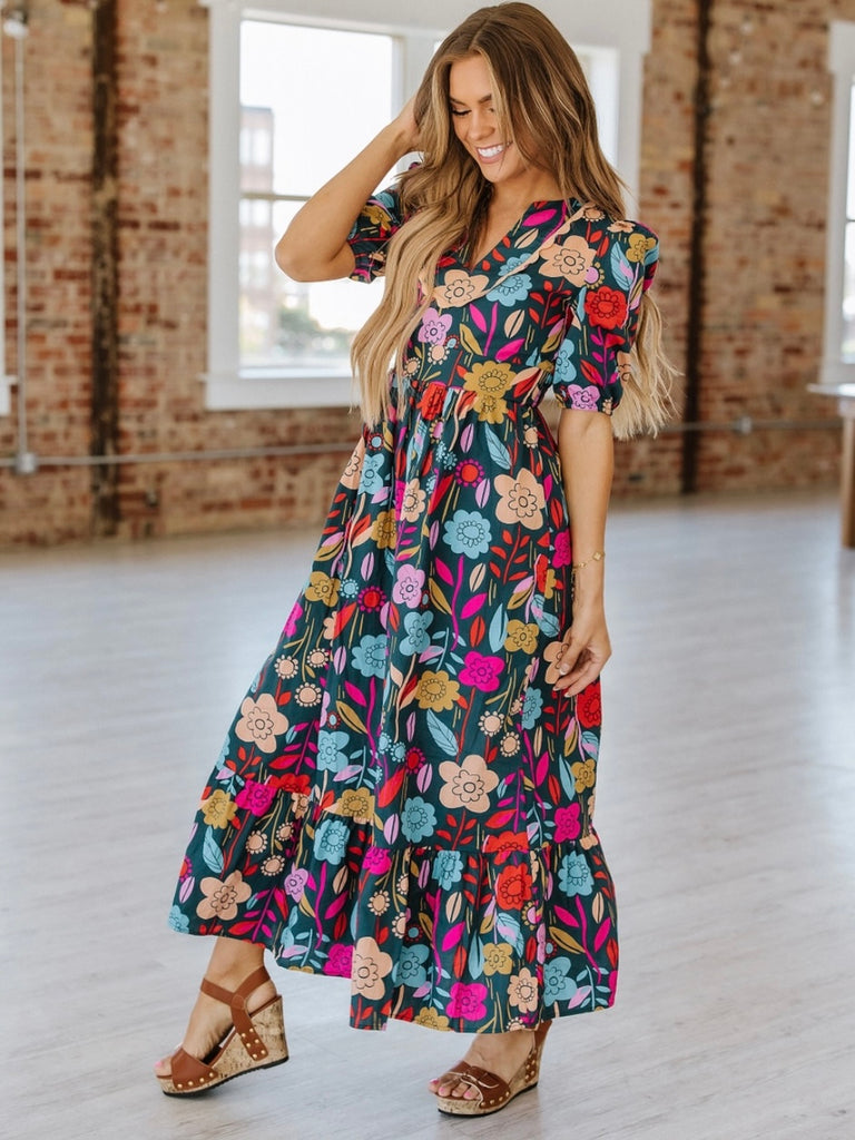 Maxi -dress features elegant puff sleeves, a flowy silhouette, and a bright floral print.