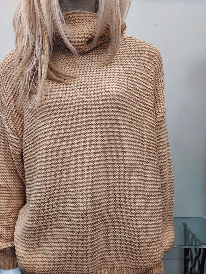 Beige colour turtleneck sweater with loose neckline and long sleeves, made from 17% nylon 28% viscose 55% polyester.