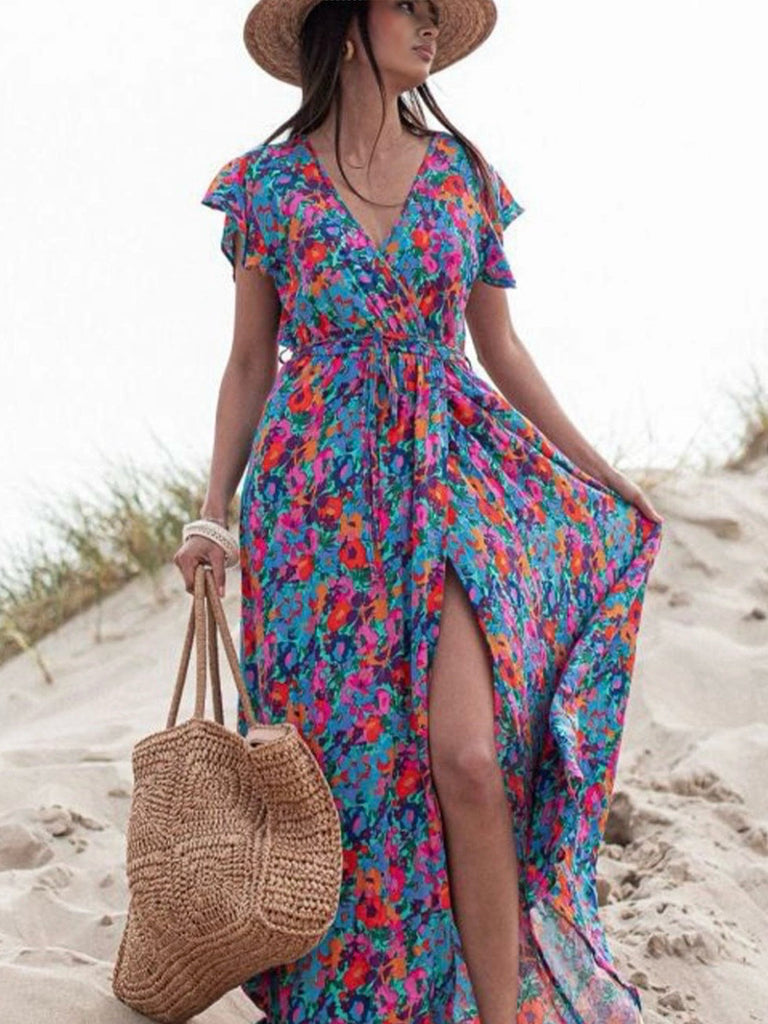 Floral Dress in vibrant shades of blue, and orange, with a high waist and side slit the v-neck wrap offers an adjustable fit.