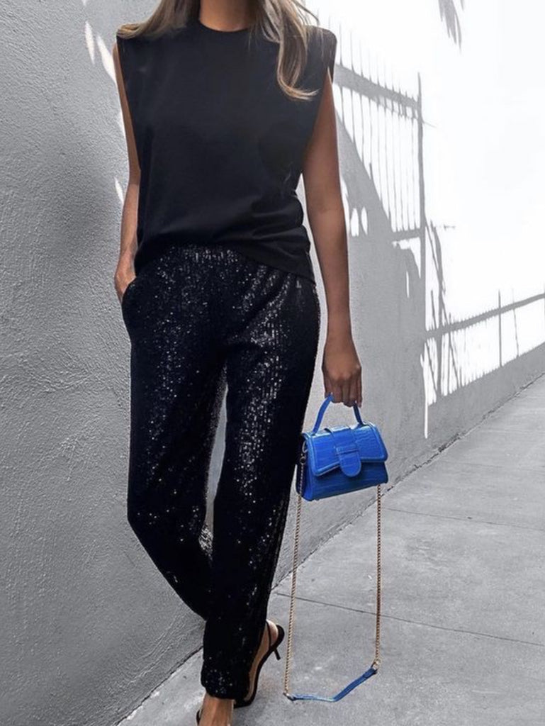 Stretchy sequin jogger pants feature an elasticated waist band and ankle cuffs and side pockets.