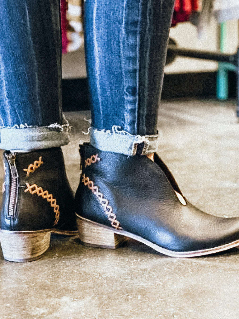 Black leather, ankle bootie with heavy stitching on the upper ,top pattern has an attractive V plunge. Zipper in the back, and a stacked heel measure 1.75 inches.