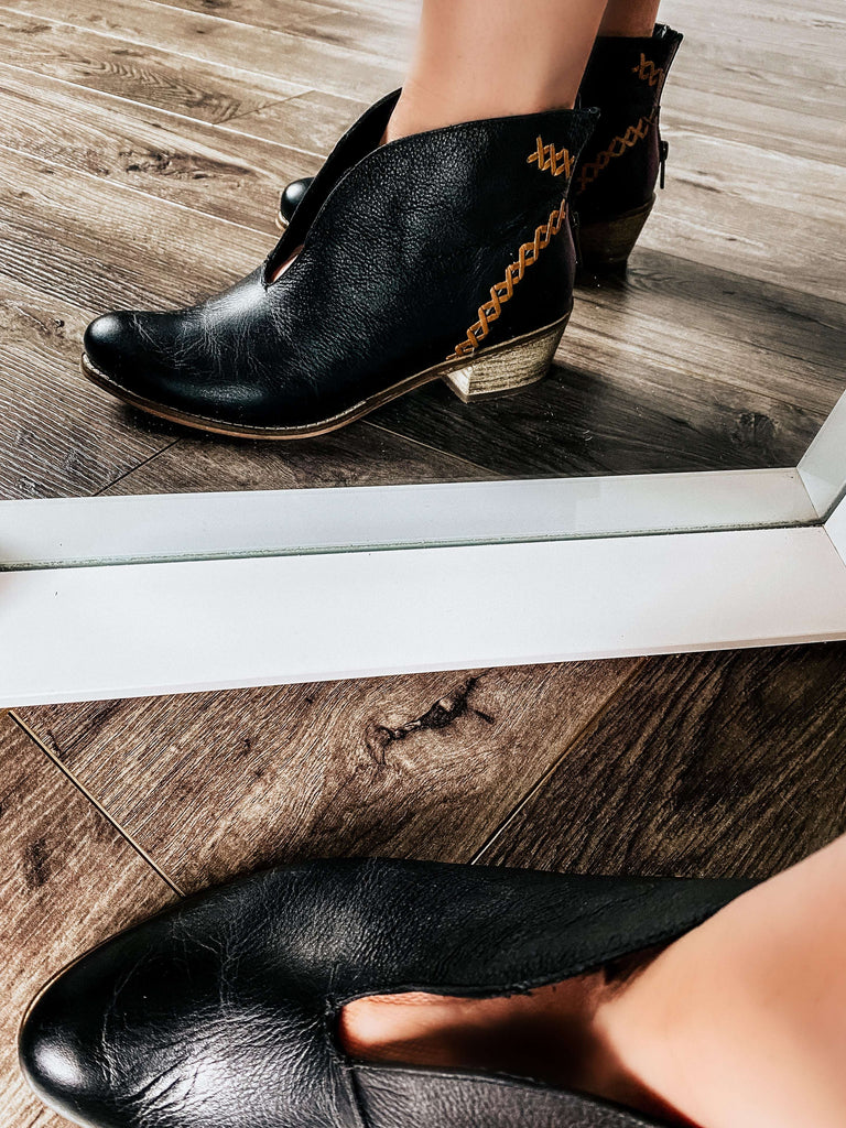 Black leather, ankle bootie with heavy stitching on the upper ,top pattern has an attractive V plunge. Zipper in the back, and a stacked heel measure 1.75 inches.