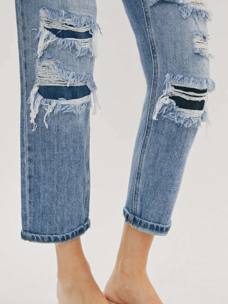 High Waisted ,5 Pocket Single Button Front and zip-fly Jean, with Light Fading and 3d Whisker detail , and moderate destruction with patches on both legs .