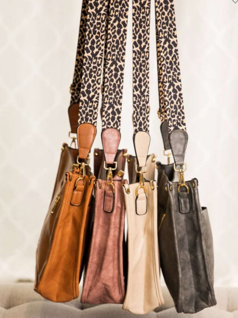  Crossbody bag with leopard print strap. Made with vegan leather, it features a full zipper closure, an exterior back zip pocket, two open slip pockets, and a zipper pocket inside.