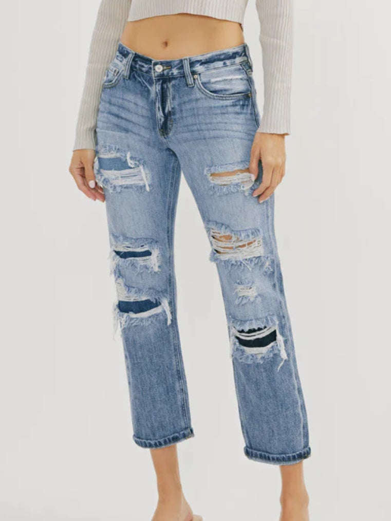 High Waisted ,5 Pocket Single Button Front and zip-fly Jean, with Light Fading and 3d Whisker detail , and moderate destruction with patches on both legs .