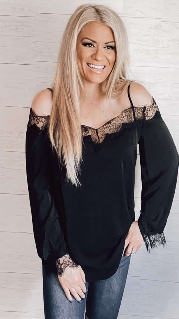 Black long Sleeve Top featuring dainty lace accents on the wrists and neckline, along with spaghetti straps, and a plunging back.