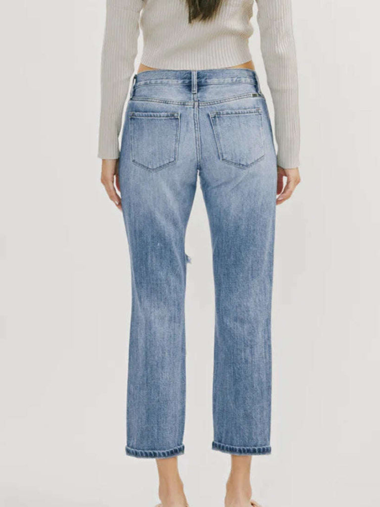 High Waisted ,5 Pocket Single Button Front and zip-fly Jean, with Light Fading and 3d Whisker detail , and moderate destruction with patches on both legs .