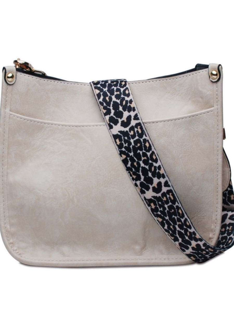 Ivory Crossbody bag with leopard print strap. Made with vegan leather, it features a full zipper closure, an exterior back zip pocket, two open slip pockets, and a zipper pocket inside.