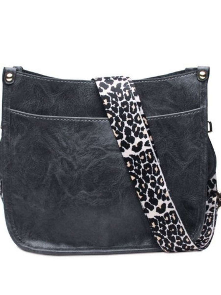 Black Crossbody bag with leopard print strap. Made with vegan leather, it features a full zipper closure, an exterior back zip pocket, two open slip pockets, and a zipper pocket inside.